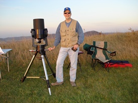 Photo of John Heasley next to telescope