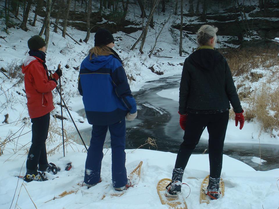 Snowshoers overlooking a stream in Winter
