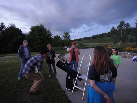 Stargazers agthered around a telescope at dusk